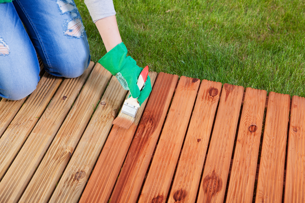 Use a paintbrush to apply an even coat of deck stain