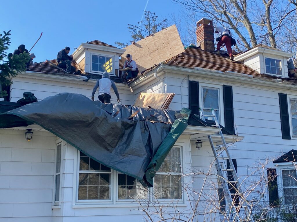 Construction crew removing and replacing an old roof