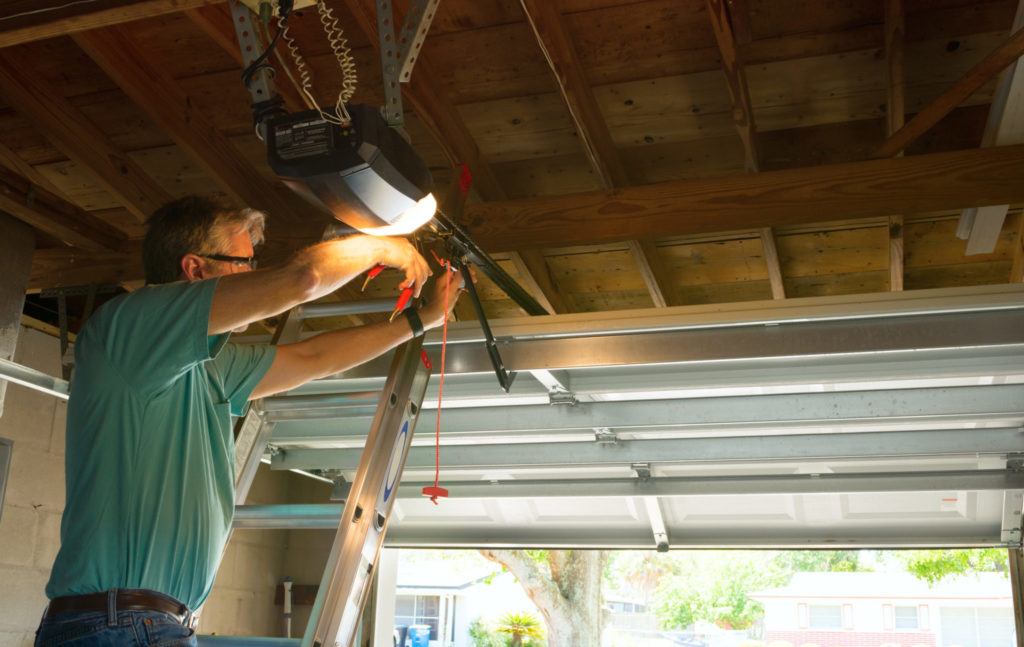 Man adjusting automatic garage door opener