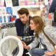 Young couple shopping for appliances, washer and dryer