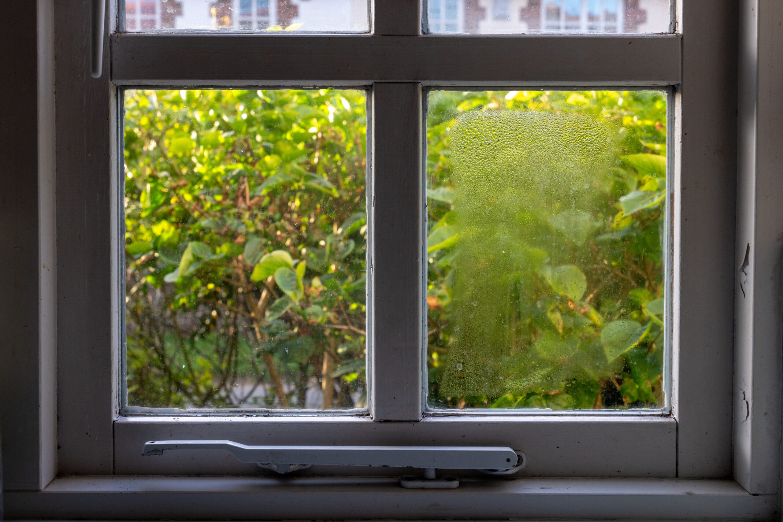 Double glazed window showing condensation droplets between two panes of glass