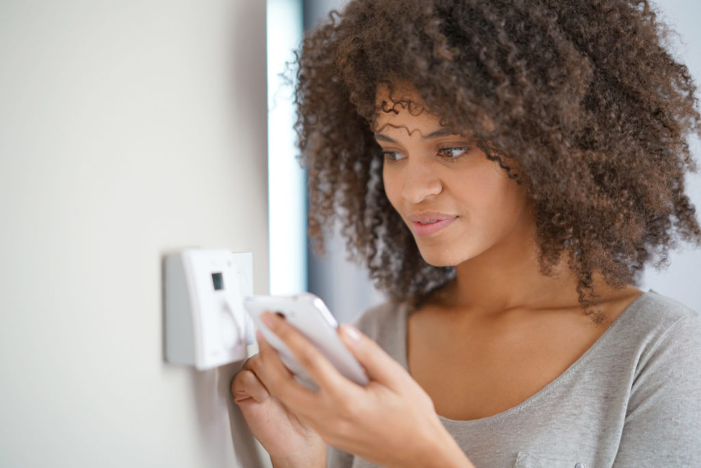 Woman adjusting a thermostat