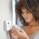 Woman adjusting a thermostat