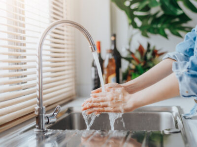 woman washing hands in sink