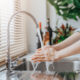 woman washing hands in sink