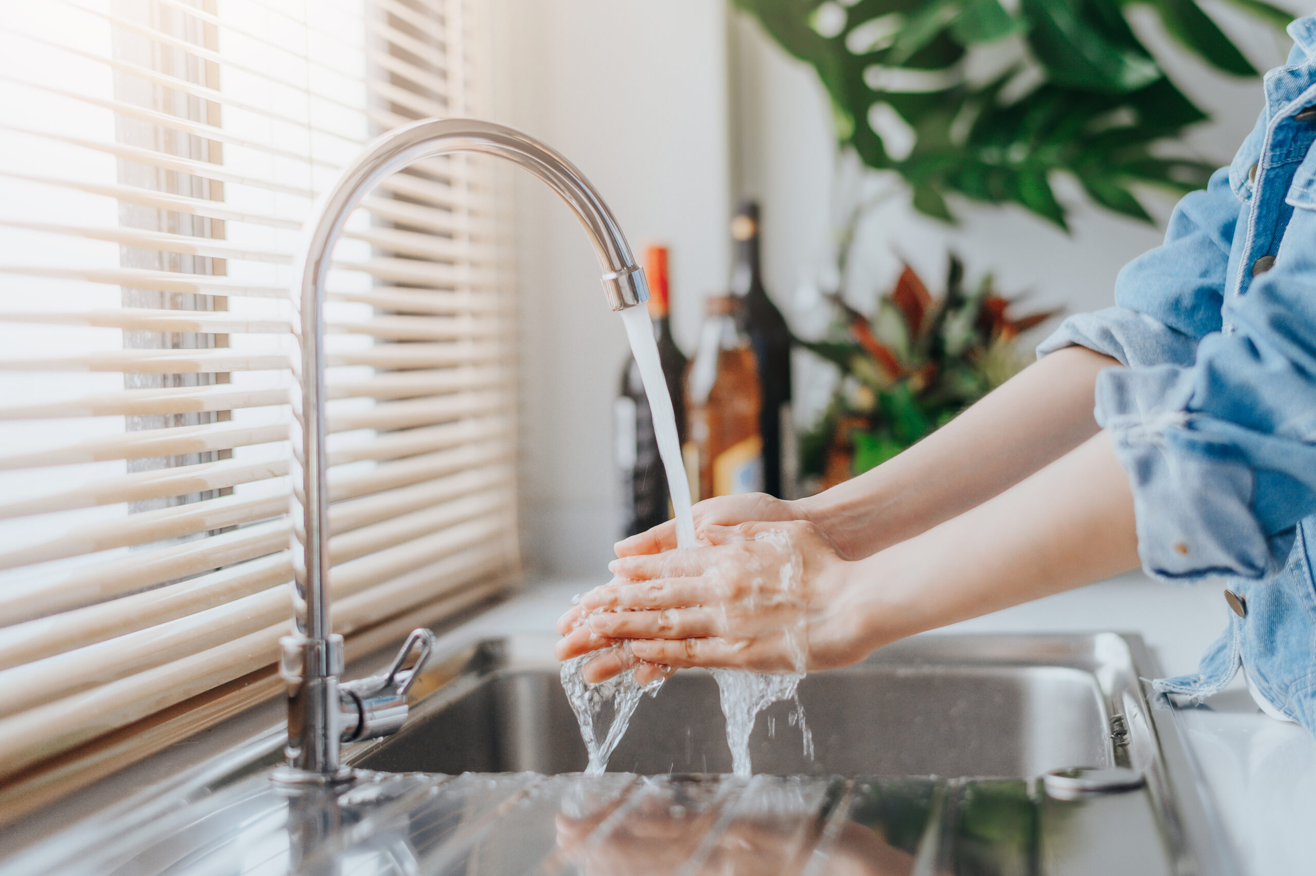 woman washing hands in sink