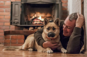 Man with dog and fireplace
