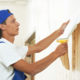 Homeowner peeling wallpaper from a wall