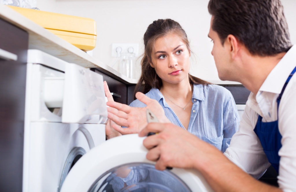 Appliance repairman and homeowner discuss broken washing machine.