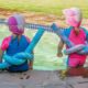 two children sitting at the edge of a pool