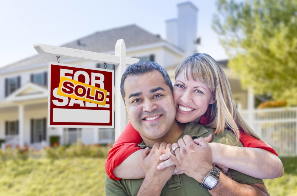 Couple hugging after buying a home