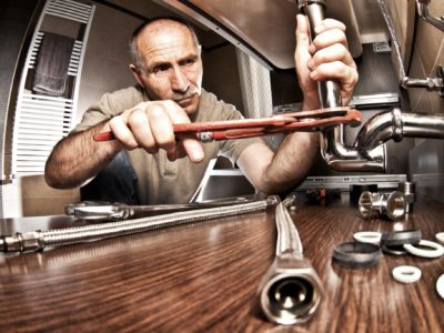 Plumber at work on pipes