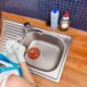 Woman clearing a clogged sink drain