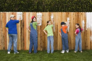 Family painting fence