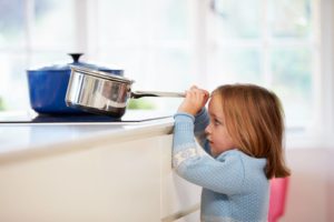 Child risking burn in kitchen