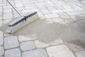 Sweeping sand on a paver brick patio