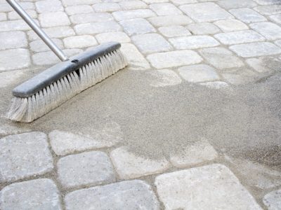 Sweeping sand on a paver brick patio