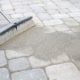 Sweeping sand on a paver brick patio