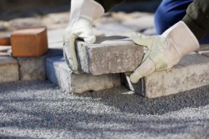 Brick patio pavers being placed on a gravel bed