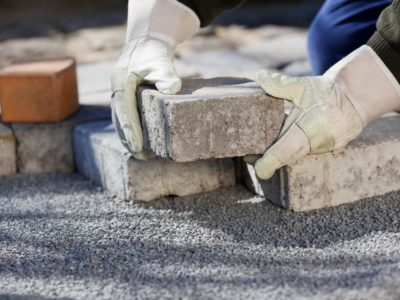 Brick patio pavers being placed on a gravel bed