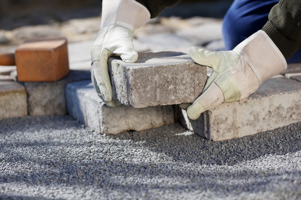 Brick patio pavers being placed on a gravel bed