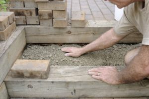 Man building brick paver patio steps
