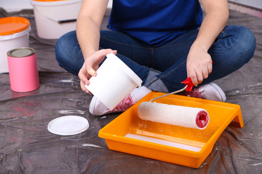 Pouring paint into a roller pan