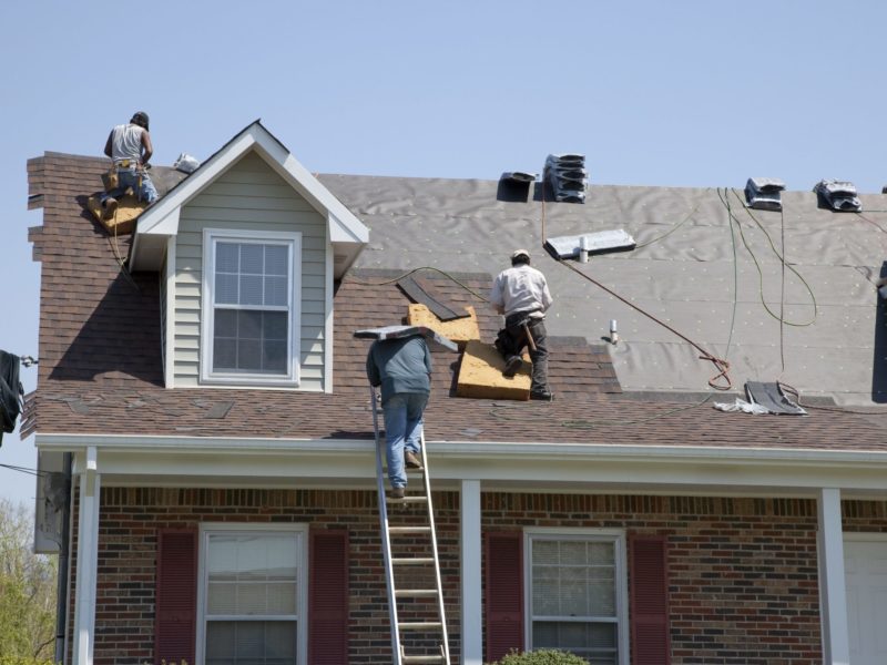 Workers replacing an older roof