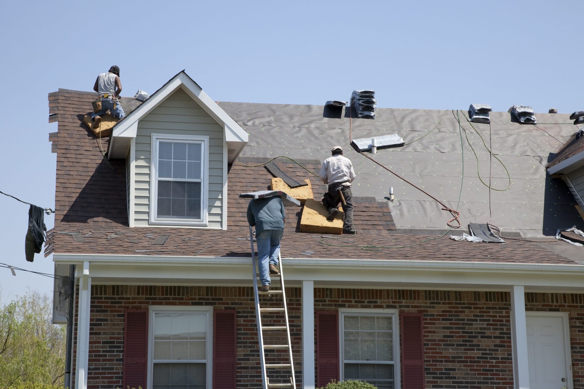 Workers replacing an older roof