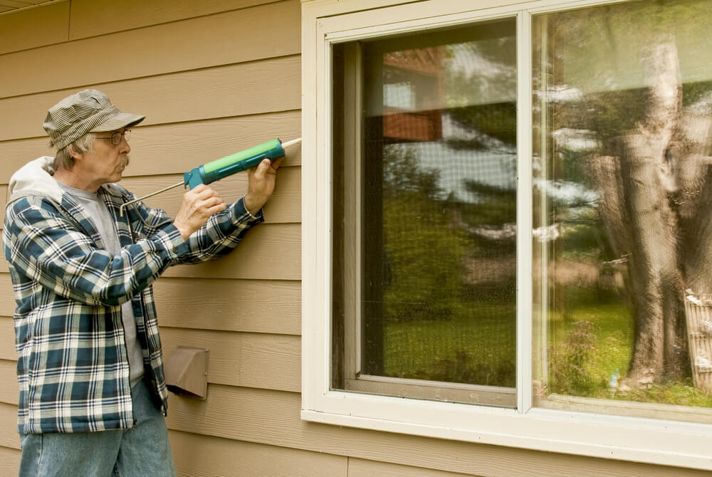 Man caulking a window