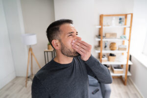 Man holding his nose to avoid musty house smell