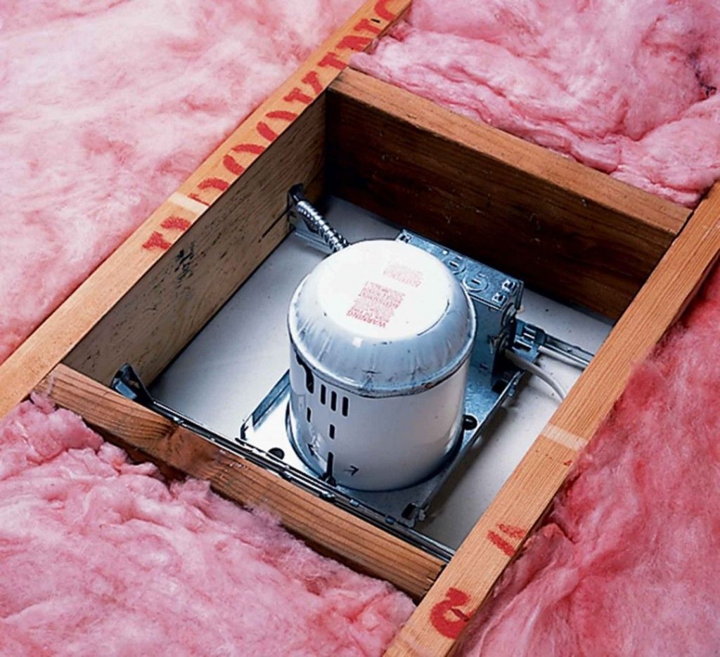 Fiberglass insulation in attic separated from recessed light to prevent overheating