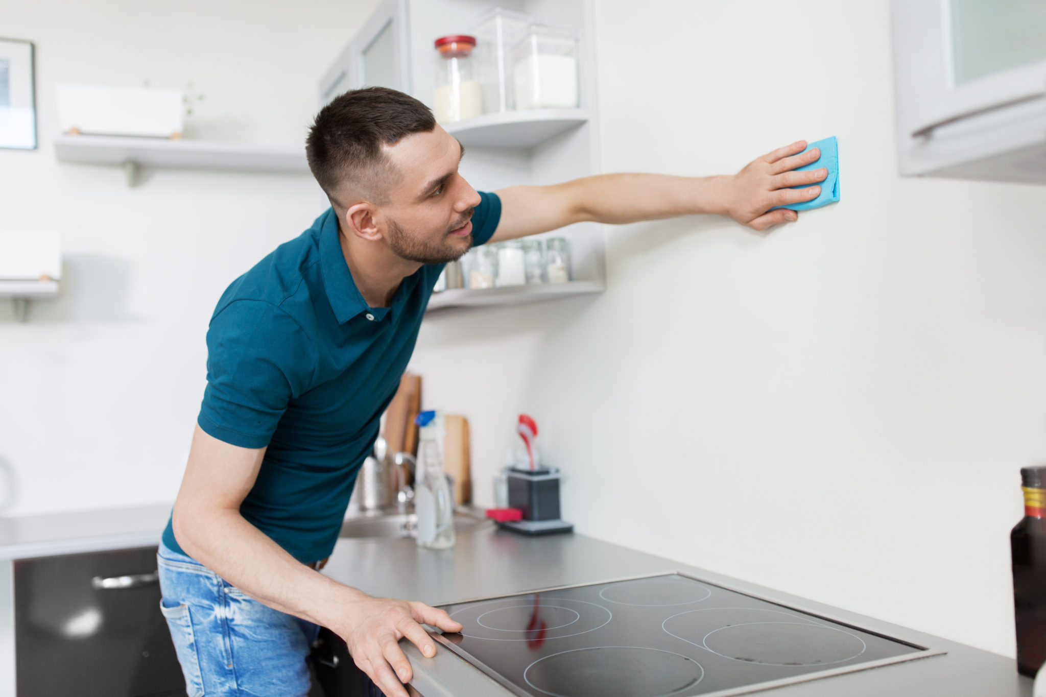 Man cleaning kitchen walls