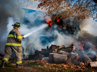 Firefighter at house with hose