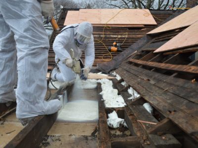 Spray foam is applied to the flat roof section from the outside.
