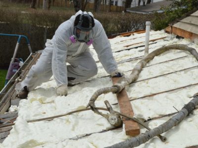 Technician applying spray foam insulation