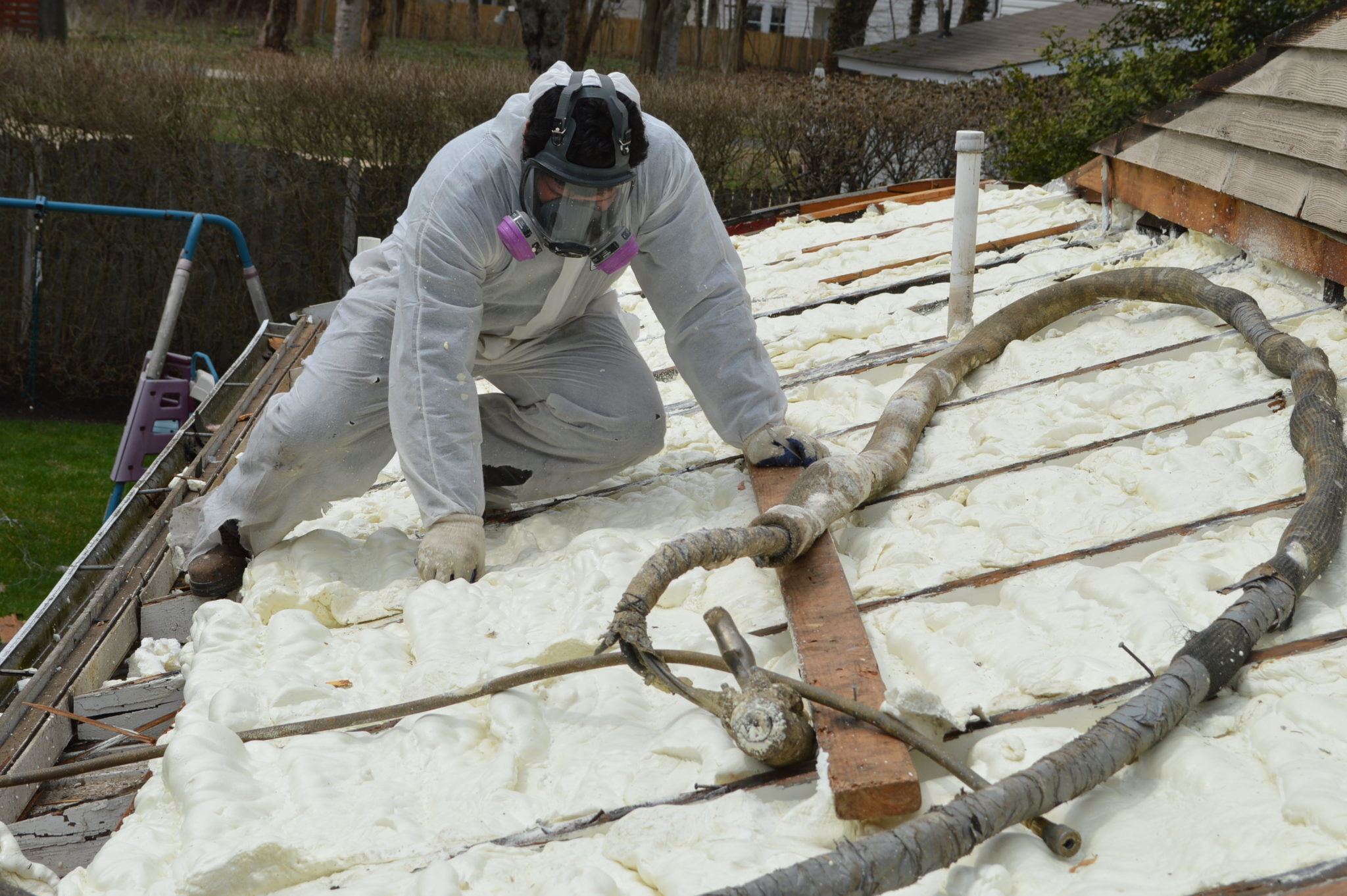 Technician applying spray foam insulation