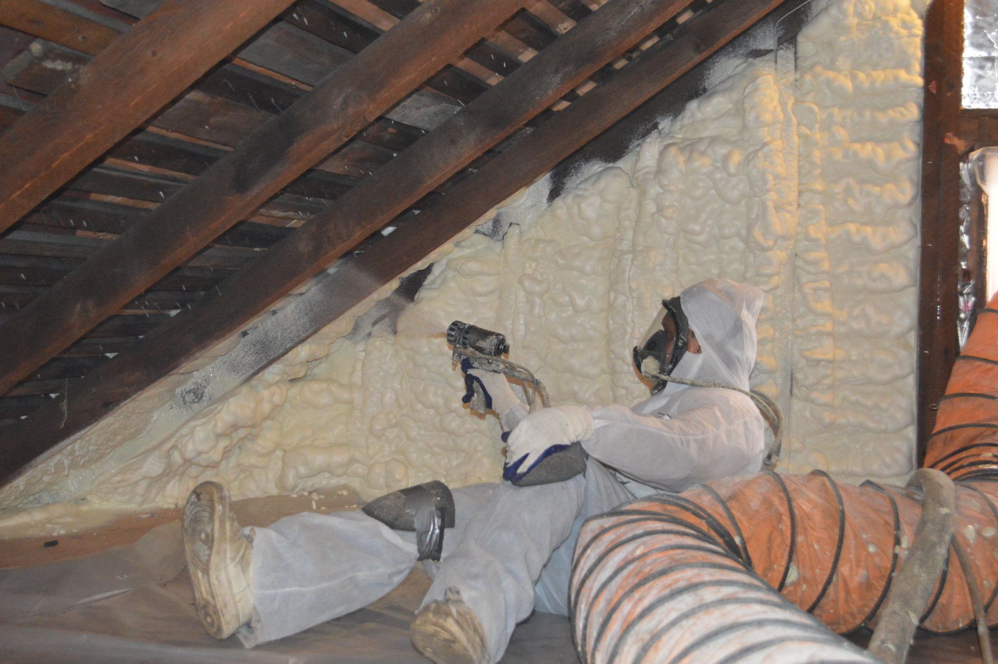 Man applying spray foam in attic