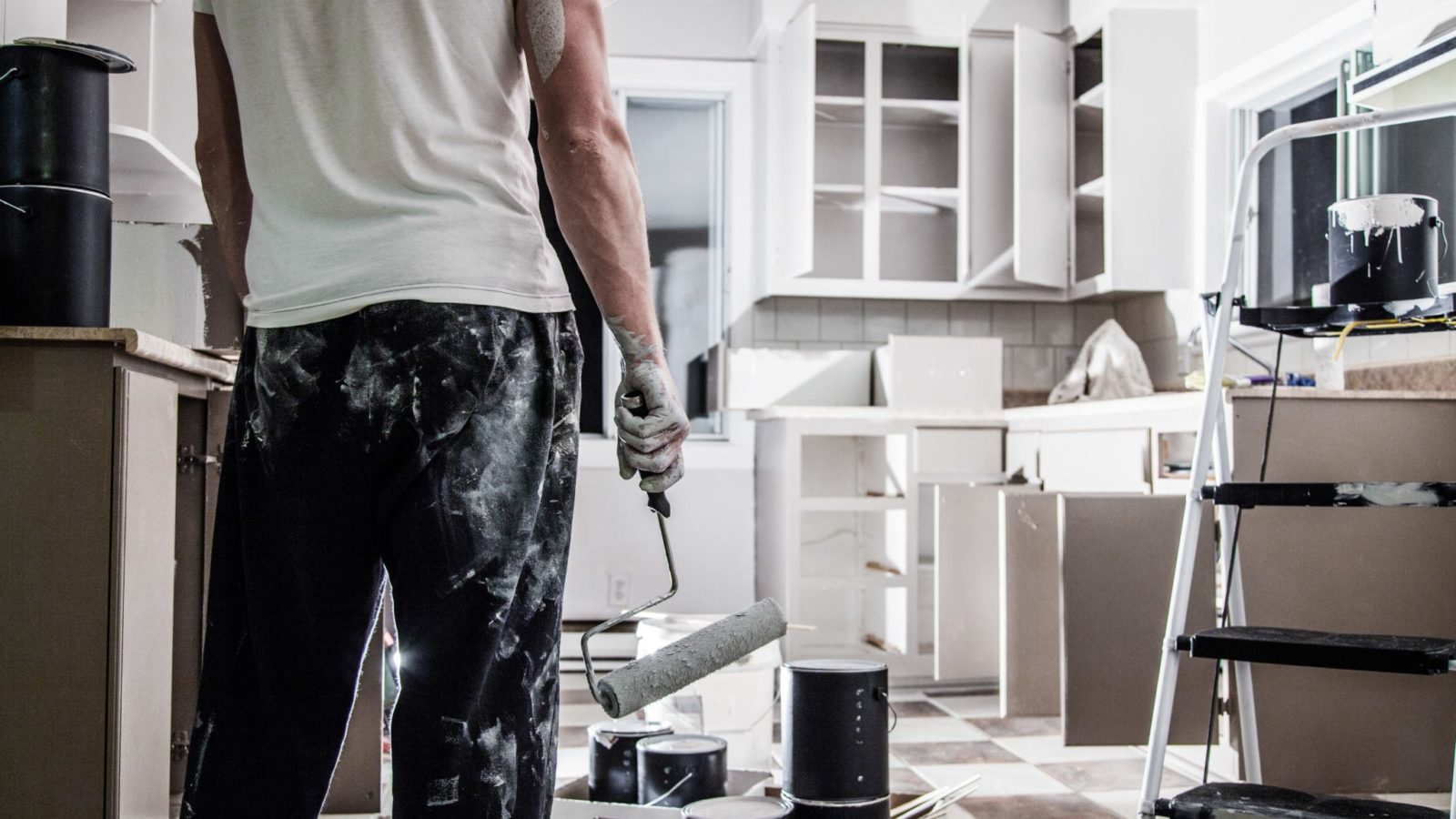 Man painting a white kitchen