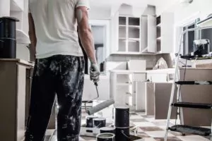 Man painting a white kitchen
