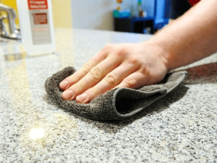 Hand cleaning a solid surface countertop