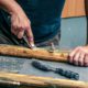 Man removing paint from an old window frame