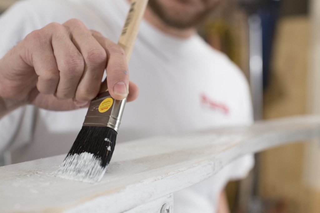 Painter using china bristle paint brush.