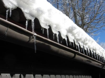 Ice dams on an old roof over a gutter