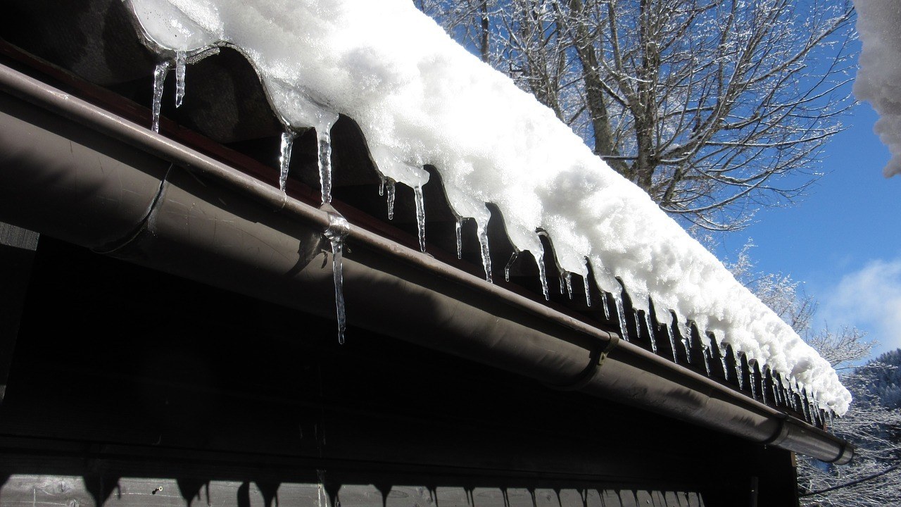 Ice dams on an old roof over a gutter