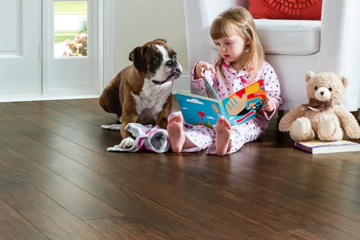 Child and dog sitting on EVP (engineered vinyl plank floor) which is durable and waterproof.