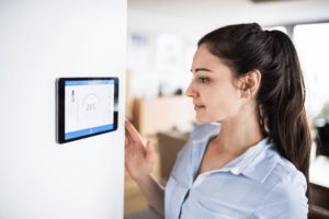 Woman using smart thermostat