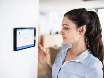 Woman using smart thermostat