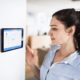 Woman using smart thermostat
