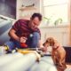 Man with small yellow dog working on a new kitchen